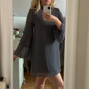 Klänning - Superfin grå klänning med volangärmar. Använd endast en gång. 