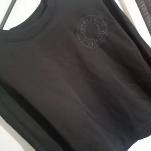 Burberry England  - Tröjan har använts 1 gång.  Mycket fint skick, helsvart med broderad logga. Tröjan är orgibal , och om så önskas, skickas fler bilder som intyg på det, kvitto på den finns tyvärr inte då min bror har gått bort. Därav det reducerade priset. (Ny 7300)