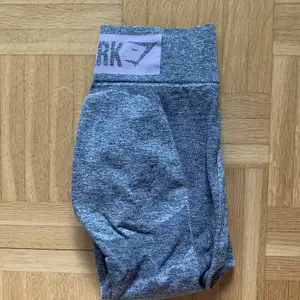Gymshark highwaist flex leggings i storlek S, gråa med ljusrosa logga ovanför rumpan, knappt använda, fint skick.