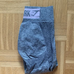 Gymshark leggings  - Gymshark highwaist flex leggings i storlek S, gråa med ljusrosa logga ovanför rumpan, knappt använda, fint skick.
