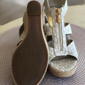 Michael Kors strl 37 - Michael Kors kilklackar strl 37. Endast använda vid 2 korta tillfällen så de är som nya. Har även en annan annons med en MK väska i samma färger:)