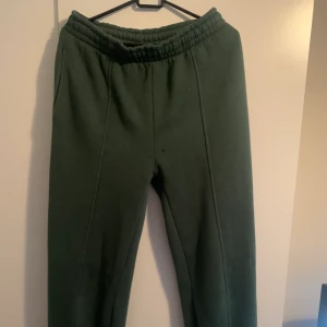 Lågmidjade Mjukisbyxor - Jag säljer ett par mörkgröna Lågmidjade mjukisbyxor! Dessvärre finns ett litet hål, men det märks ej så mycket när man har byxorna på💕 Storlek M och byxorna är från ginatricot. Bild med byxorna på kan fås privat!