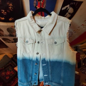 Blå och vit jeansväst - Fin blå och vit jeansväst! Köpt second hand men aldrig använt av mig och är i väldigt bra skick. Det vita är lite mer off-white. Katt och hund finns i huset, men är som sagt aldrig använd av mig🧡  Står ej för frakt:)