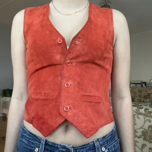 Vintage Mockaväst - Väst i äkta mocka framtill och tjockt glansigt material baktill❤️ storlek 40 men passar mig som brukar ha storlek 36. Går att justera med ett band på ryggen