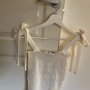 Sött linne - En aldrig använd topp med rosetter på axelbanden. Hur söt som helst och perfekt på sommaren. Aldrig använt pga inte min stil