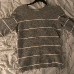 Randig stickad tröja - Grå stickad tröja med vita ränder. Från barnavdelningen på h&m men passar en XS då den är stor i storleken. Skick 9/10