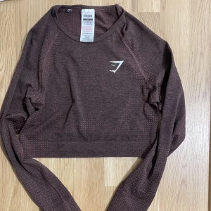 Gymshark vital seamless long sleeve crop top - Gymshark vital seamless long sleeve crop top. En äldre version av deras vital seamless i färgen brown marl 🌸