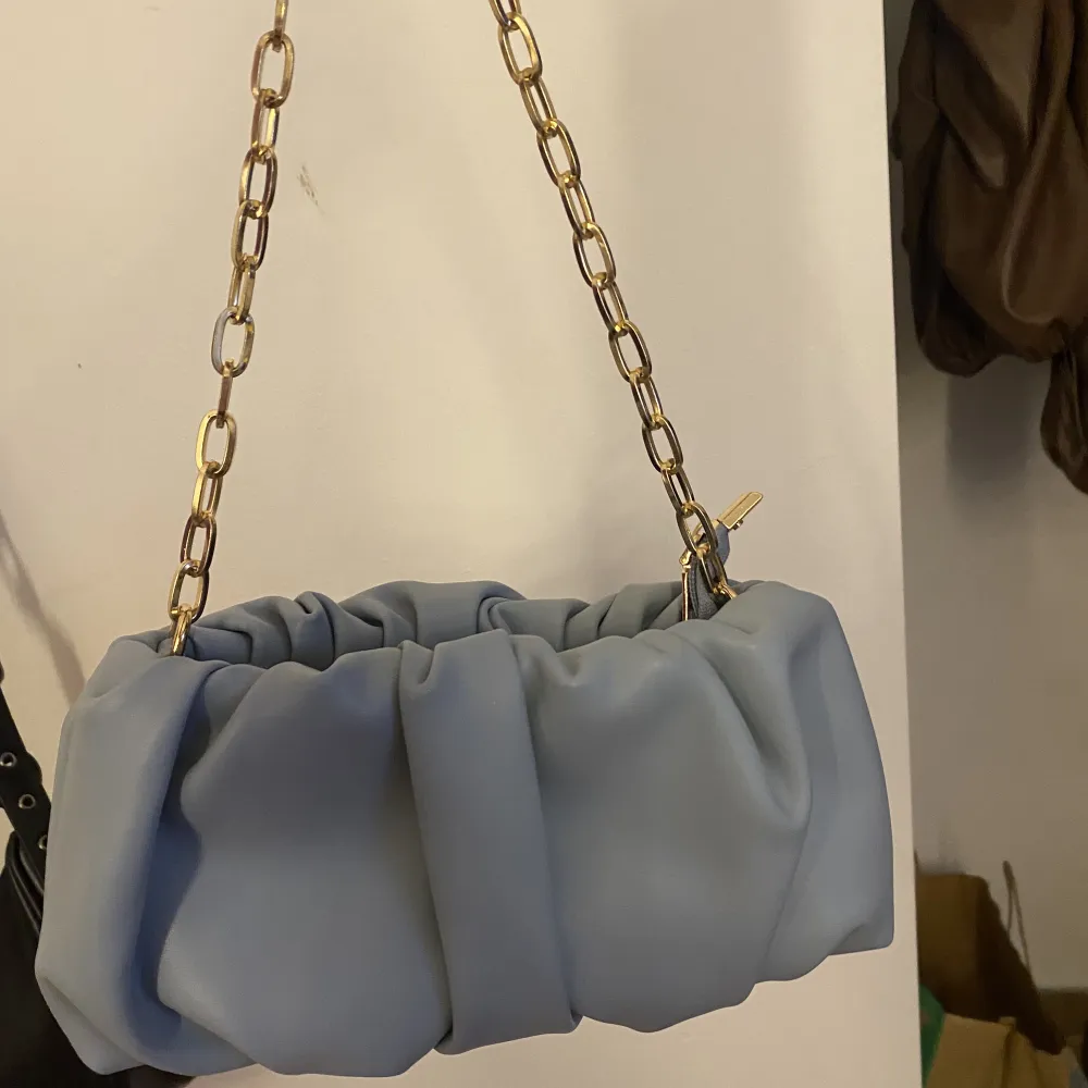 En blå skrynklig väska med äkta metall kedja i guld  Rymlig väska . Väskor.