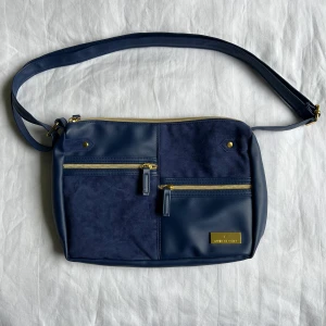 Väska 🌀 - En blå väska med gulddetaljer 🌀