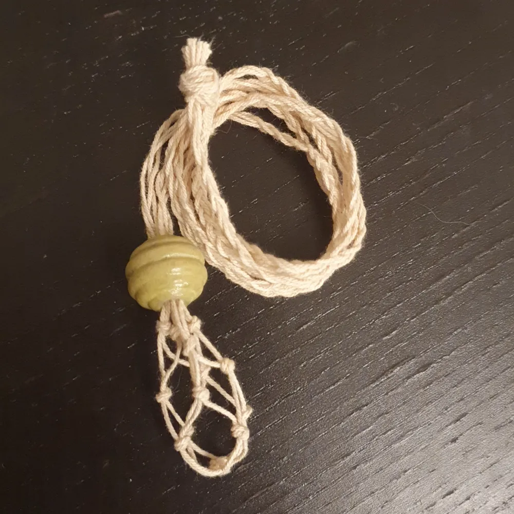 Ett halsband till kristaller. KOMMER EJ MED KRISTALL! Ca 72 cm runt halsen. En grön pärla med lite kurvor. Man öppnar genom att skuta upp pärlan.. Accessoarer.