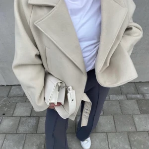 Beige kappa  - Kappa från NAKD, aldrig använd. Lappen är kvar. Storlek 34 så passar en XS-M. Den är oversized i modellen. Säljer vid bra bud. Slutsåld på hemsidan.