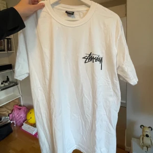 Our Legacy workshop x Stussy - Vit T-shirt med tryck på båda sidor från Our Legacy Workshop x Stussy. Knappt använd. 