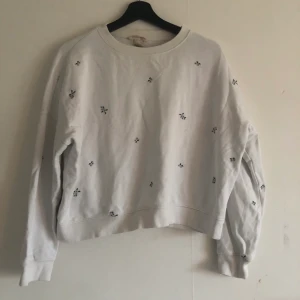 Croppad sweater med broderade blommor - Något croppad sweater från H&M i storlek M. 