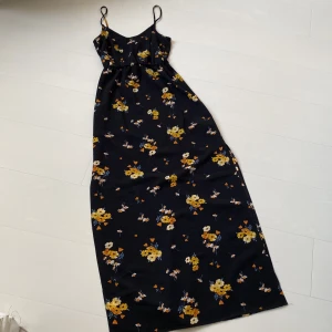 blommig långklänning med slits - blommig långklänning i tunnt material. klänningen har en slits som går upp på låret. köparen står för frakten. 