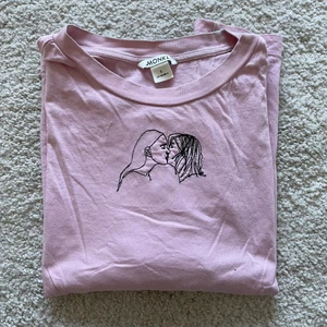 Lesbisk T-shirt Monki - Rosa t-shirt med lesbiskt broderi från Monki. Storlek S. Liten missfärgning från hårfärg runt halsen, framförallt på insidan. Byst 52 cm (x2) Längd: 58 cm (mätt liggande platt)