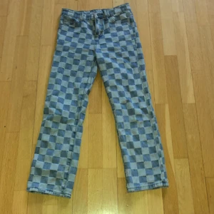 Rutiga jeans i stl 140 - Rutiga coola jeans från Shein. Dom är i bra skick förutom att knappen sitter lite löst. 