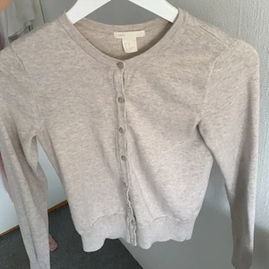 beige/grå kofta - beige/grå kofta med knappar från hm i storlek xs!!! jättefin att ha över toppar