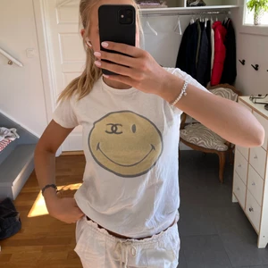 T-shirt  - Vit T-shirt med smiley på. Storlek xs men passar mer som en S-M 