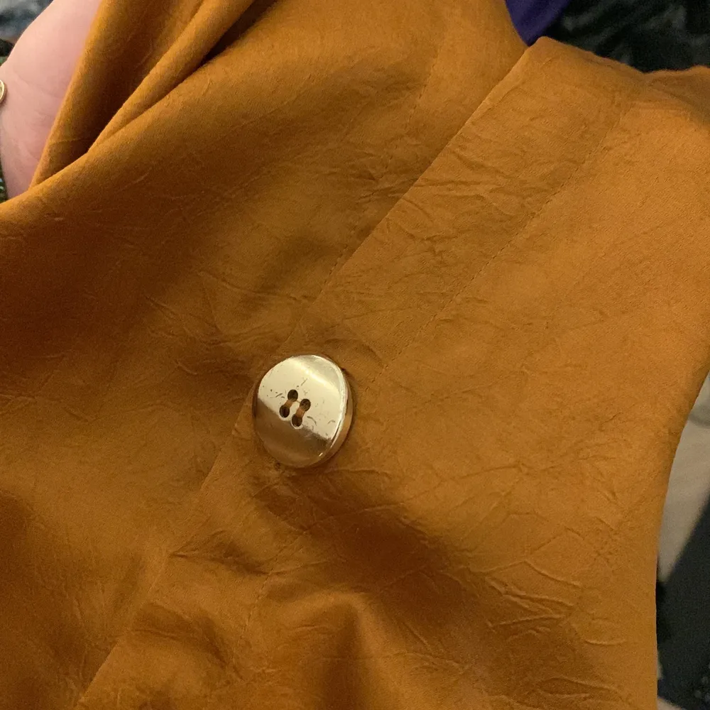 Orange oversized skjorta/blus från GinaTricot med ”guldiga”/mässings knappar! Med mönstrade detaljer i tyget. Den är dessvärre lite fläckig!. Blusar.