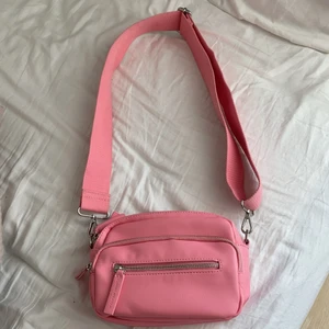 Väska  - Säljer en rosa superfin väska från Carin wester då den inte kommit till användning, nypris 499, använd 3 ggr så därför som nyskick 