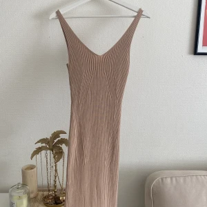 Beige stickad klänning - Så fin & bekväm långklänning. Ej ull, så inte varm, funkar året runt! Perfekt skick, använd en gång. Slits baktill.