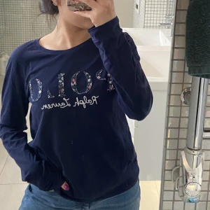 Mörkblå Ralph Lauren T-shirt - Långärmad mörkblå Ralph Lauren T-shirt med tryck på, knappt använt. Som storlek xs/s men är egentligen barnstorlek, storlek 170 (16 år)