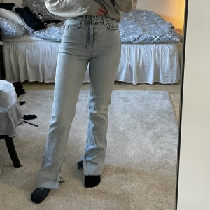 Gina jeans med slits - Ljusblå jeans med slits nertill, storlek 32. Har använt dom ett fåtal gånger. 