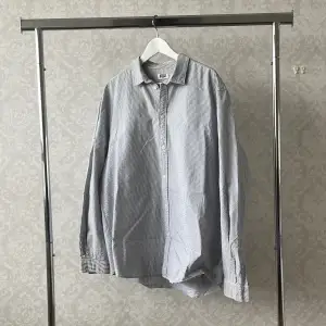 en vit/blå randig skjorta från weekday med en dropshoulder/oversize fit. 