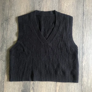 Svart stickad väst - Svart stickad väst köpt på Plick 2020, står ingen storlek men skulle säga att de passar de flesta beroende på hur man vill att den ska sitta! Själv brukar jag bära xs/s! :)