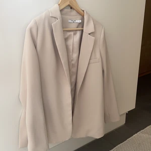 Blazer - Blazer från nakd i beige med slits vid sidorna. Använd ca 1-2 gånger och tror den kan vara slutsåld. Storlek 36. Är 167 cm lång och den passar väldigt bra på mig.