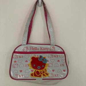 As söt Hello Kitty väska från ca 2009! Lite sliten på banden därav priset men funkar som vanligt!! Längd: 24cm Höjd: 15 cm Bredd: 8cm