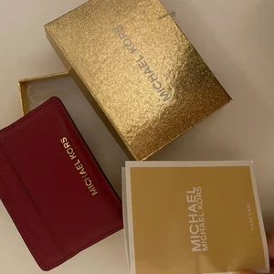 Korthållare  - En Michael kors korthållare med alla tillbehör, korthållaren är i en röd/rosa likande färg som är i de mörka tonerna🍒