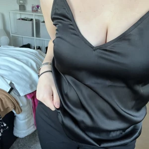 Satinlinne - Svart satinlinne från Vero Moda. Ryggen är formad som ett H med banden.