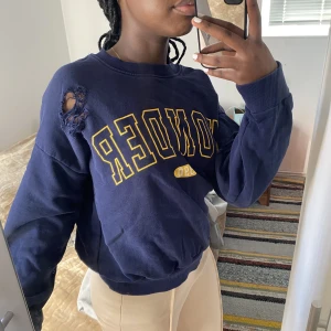 Blå tjocktröja med hål och tryck - Säljer denna blåa tjocktröjan som tyvärr inte kommer till användning längre. Var väldigt poppis förrut med hålen runt om på tröjan. Använd ett par gånger men syns inga tecken på användning! Den är i S men är lite oversized.💙 Skriv för mer bilder.