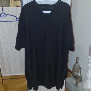 Lång skjorta  - Svart lång skjorta med fickor