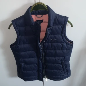 GANT väst strl 158/164 - Mörkblå gant väst i storlek 158/164. Köptes på NK i Stockholm för några år sedan för 1299 kr och har knappt används så den är i princip som ny.