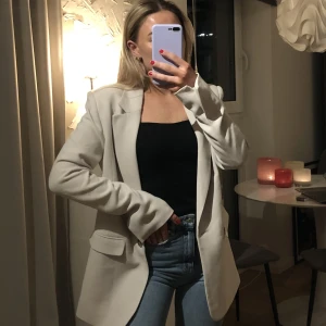 Beige kavaj med textur - Jättesnygg beige kavaj med textur i storlek 34, säljer pga att den inte kommer till användning. Köpt för 799kr