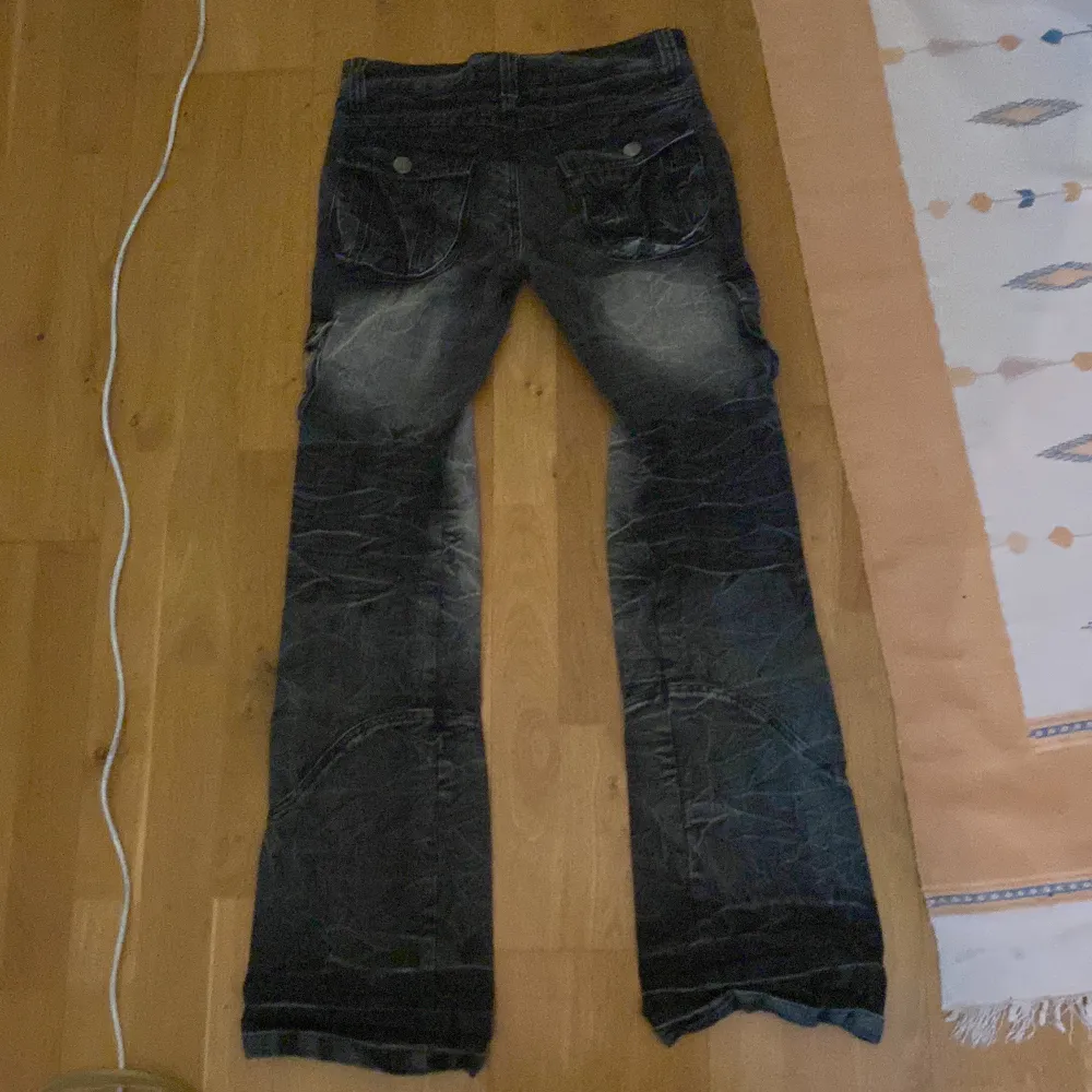 Säljer ett par japanska cargo-jeans i storlek 28/29, de är bootcut med en low rise och har massa snygga detaljer Midja: 76cm Rise: 22.5 cm Längd: 101cm Benöppning: 23cm. Jeans & Byxor.