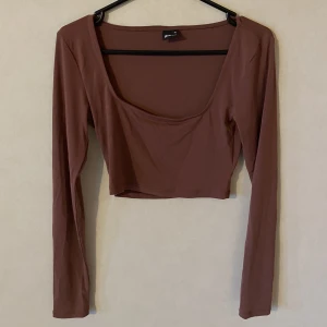 Croppad topp från Gina Tricot - Passar även storlek S. Mullvadsfärg.