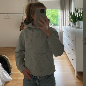 Tommy Hilfiger hoodie - Snygg grå Tommy Hilfiger hoodie i gott skick! Lätt croppad i modellen med en stor härlig luva.
