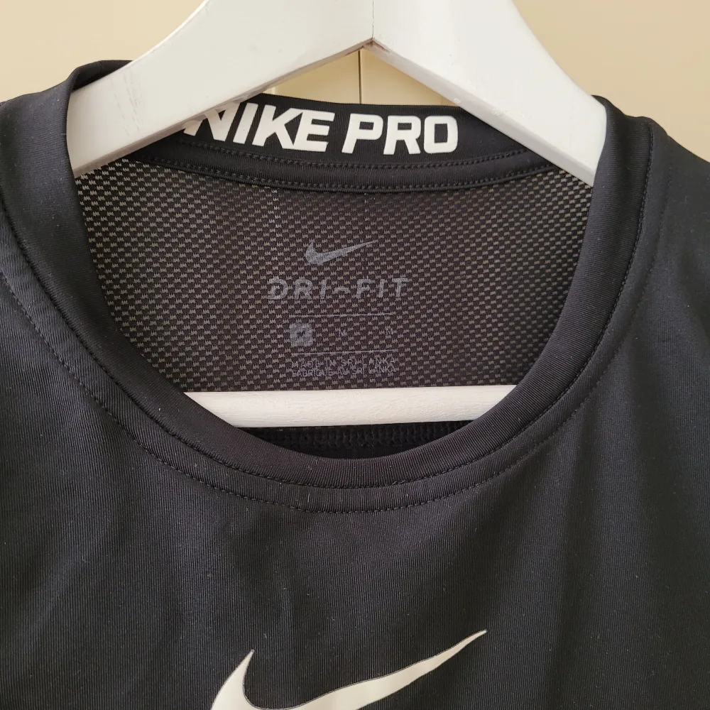 Svart Original Nike Pro Dri-fit  träningströja/undertröja i superskönt material. Använd, välvårdad. Som ny förutom en tunn reva i ryggen,  men inget som stör! Stl.M herr, slim modelll. Passar perfekt till tjej stl.M. Nypris 450:-. Hoodies.
