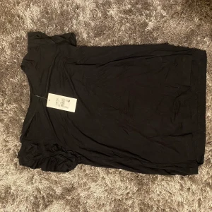 Svart T-shirt med volanger  - En vanlig svart T-shirt med ass snygga volanger som gör en snygg detalj!! Köpt från Cubus (fick när jag fyllde år) 