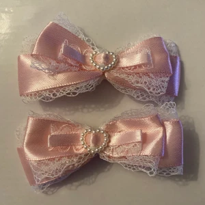 Handgjorda hårrosetter  - Små hårrosetter i rosa satin och spets! Söta att ha i håret till pigtails och andra frisyrer! Kommer självklart i par!