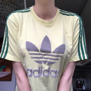 Adidas tröja i cool färg - En solgul adidas tisha med gröna stripes, och reflex logga. Bekväm och i toppen skick! 