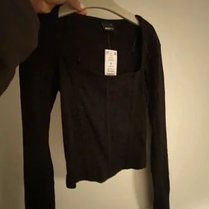 Helt ny Urringad svart topp  - Helt ny topp!! Skitsnygg till fest och middagar. Aldrig använd pga inte min stil. Köpt på Gina, frakt tillkommer 🥰passar xs-m