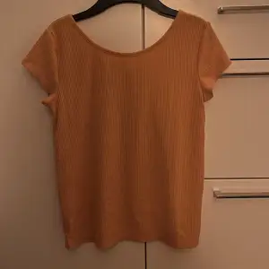 Ribbstickad senapsgul/orange t-shirt från Lindex (färgen syns inte riktigt på bilden tyvärr)! Storlek står 158/164 men passar S