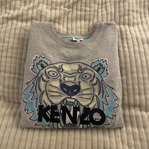 Kenzo Tröja - Grå kenzo tröja (Äkta), köpt ungefär 1 år sen. Knappt använd i gott skick! Storlek M men passar som S/Xs.  Nyköpt för 2000 säljer för 500