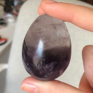 ametist ägg - ett superfint ametist ägg, med jättemycket shimmer i som man kan se innuti stenen från olika vinklar, försökte visa detta på tredje bilden med de är svårt att få dens sjönhet på bild. ungefär 5 cm på längden och 3,5 cm på bredden, väger cirka 85 gram.