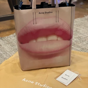 Acne studios tote bag - Säljer tote bag från Acne studios i modellen Baker. Det finns en liten repa på väskan (se bilder) som inte syns när man bär den, annars toppen skick! Lätt att sköta om då man kan torka av med fuktig trasa. Har en axelrem och ficka med dragkedja på insidan.  WIDTH: 27 cm  HEIGHT: 33 cm  DEPTH: 12 cm  