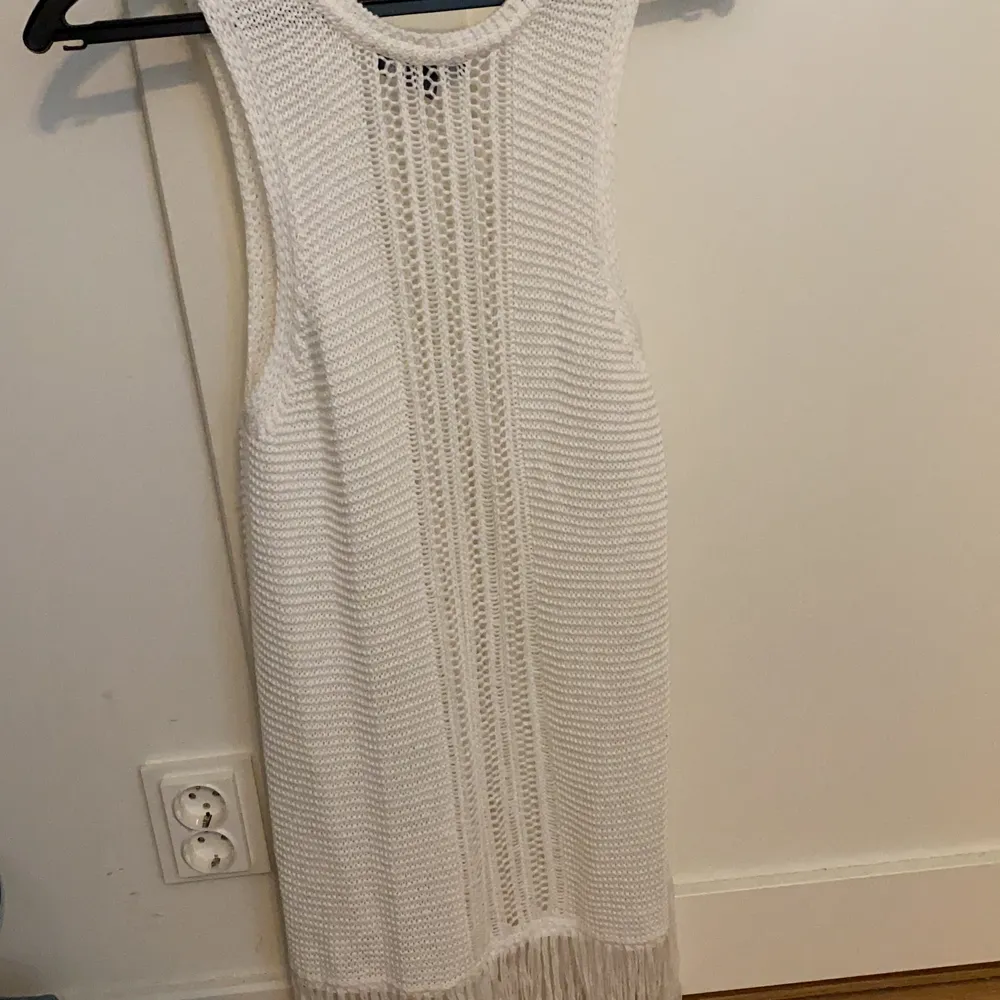 En vit stickad strandklänning som tyvärr aldrig kom till användning:)). Klänningar.